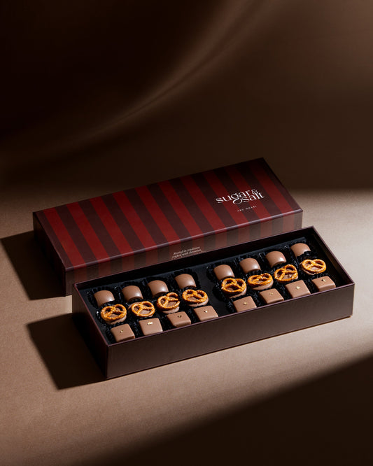 Chocolate assortment in a striped box on a brown background